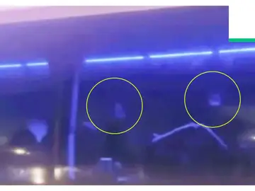 Dos futbolista iraníes realizan un supuesto gesto de auxilio desde el autobús Dos futbolista iraníes realizan un supuesto gesto de auxilio desde el autobús