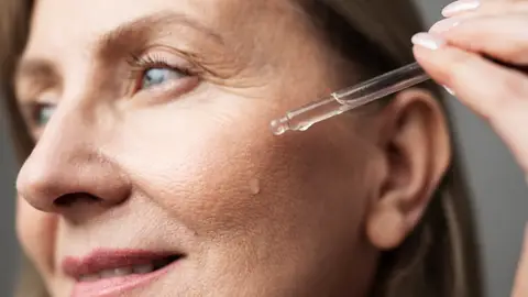 Mujer aplicándose séurm Mujer aplicándose séurm