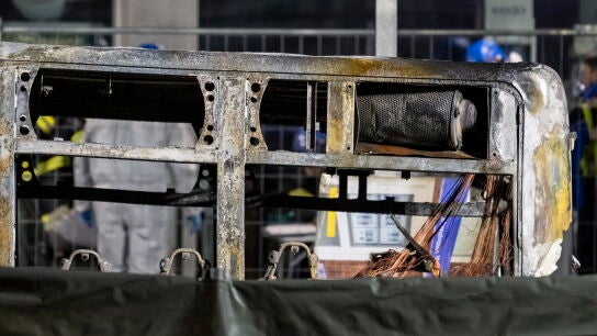 The rear of the charred shell of a postal bus stands after it caught fire in Kerzers, Switzerland, 10 March 2026