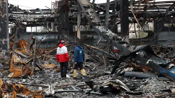 Miembros de la Media Luna Roja Iraní se encuentran entre los restos de vehículos en un taller mecánico en Teherán Miembros de la Media Luna Roja Iraní se encuentran entre los restos de vehículos en un taller mecánico en Teherán