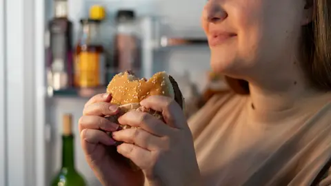 Mujer comiendo una hamburguesa Mujer comiendo una hamburguesa