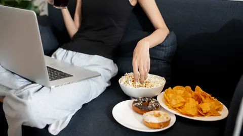 Mujer con palomitas, dónuts y patatas fritas Mujer con palomitas, dónuts y patatas fritas