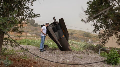 03 April 2026, Israel, Shadmot Mehola: An Israeli man looks at a tail section of a ballistic missile launched from Iran, in the Jewish settlement of Shadmot Mehola in the northern Jordan Valley. Photo: Oren Ziv/dpa 03/04/2026 ONLY FOR USE IN SPAIN