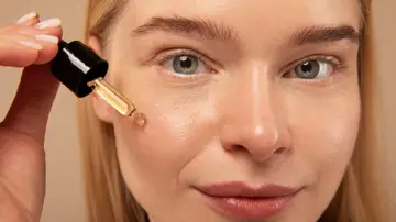 Mujer aplicándose un cosmético Mujer aplicándose un cosmético