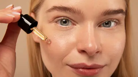 Mujer aplicándose un cosmético Mujer aplicándose un cosmético