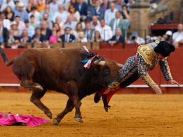 El diestro Morante de la Puebla sufre una cogida durante la novena corrida de la Feria de Abril de Sevilla con reses de la ganader&iacute;a de Hermanos Garc&iacute;a Jim&eacute;nez