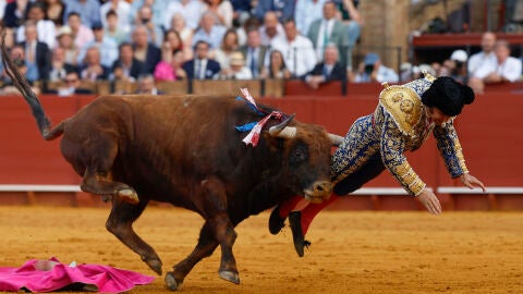 El diestro Morante de la Puebla sufre una cogida durante la novena corrida de la Feria de Abril de Sevilla con reses de la ganader&iacute;a de Hermanos Garc&iacute;a Jim&eacute;nez
