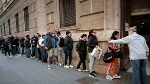 Un gran n&uacute;mero de personas guarda cola ante el padr&oacute;n municipal de Valencia