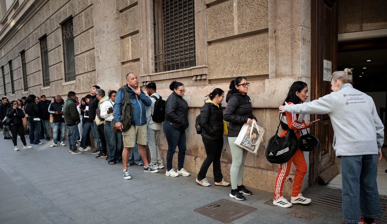 Un gran n&uacute;mero de personas guarda cola ante el padr&oacute;n municipal de Valencia
