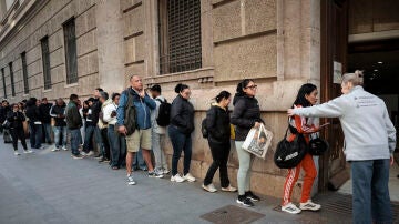 Un gran n&uacute;mero de personas guarda cola ante el padr&oacute;n municipal de Valencia