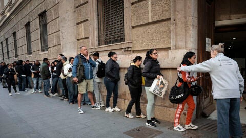 Un gran n&uacute;mero de personas guarda cola ante el padr&oacute;n municipal de Valencia