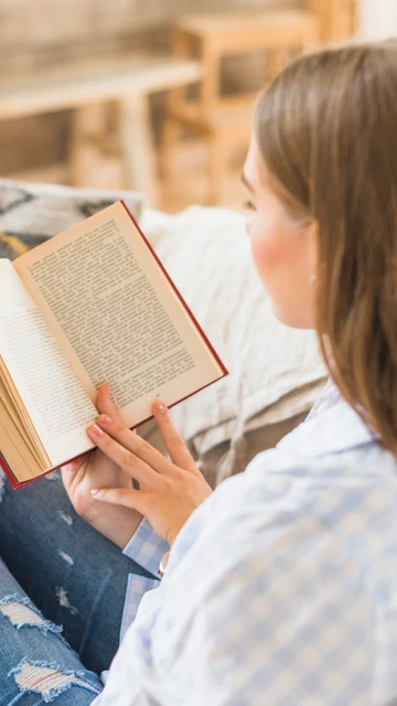 Mujer leyendo un libro en el sofá