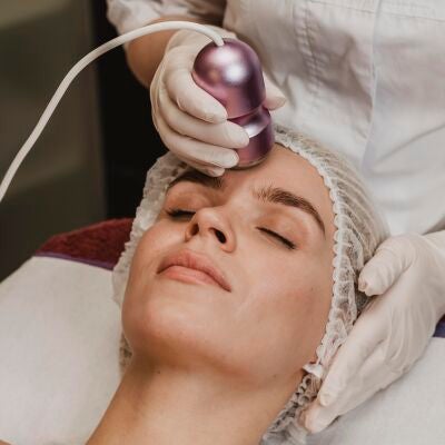 Mujer haci&eacute;ndose un tratamiento facial con l&aacute;ser