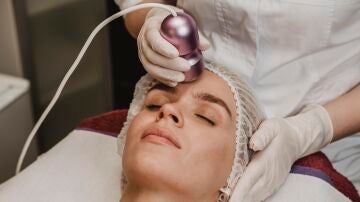 Mujer haci&eacute;ndose un tratamiento facial con l&aacute;ser