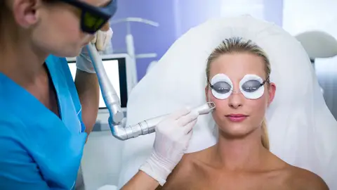 Mujer haciéndose un tratamiento facial con láser Mujer haciéndose un tratamiento facial con láser
