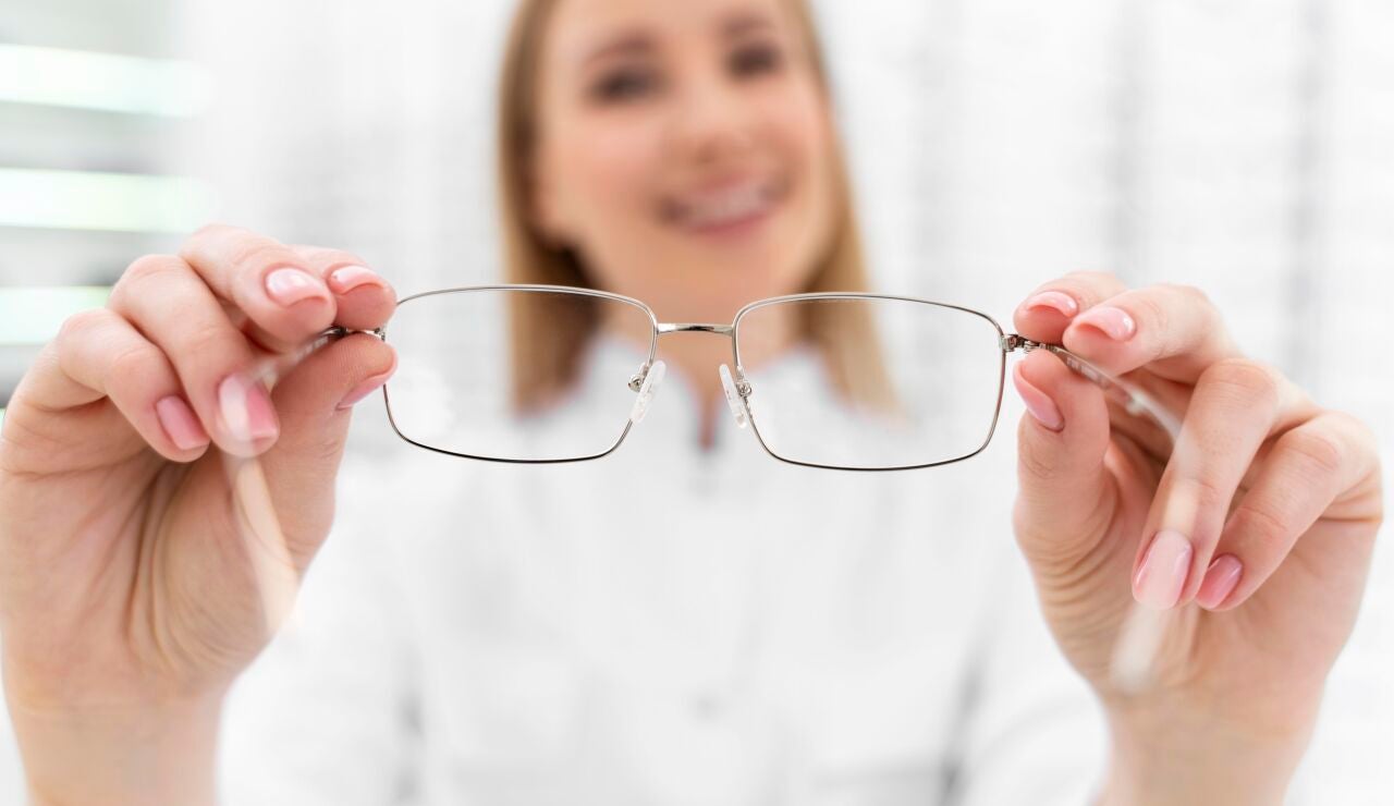 &Oacute;ptica con unas gafas en la mano