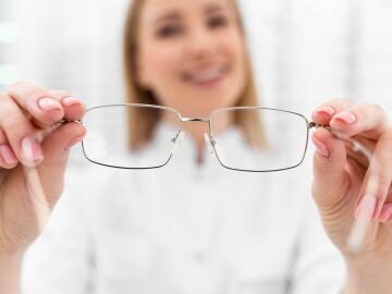 &Oacute;ptica con unas gafas en la mano