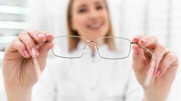 &Oacute;ptica con unas gafas en la mano