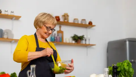 Mujer preparando una ensalada en la cocina Mujer preparando una ensalada en la cocina