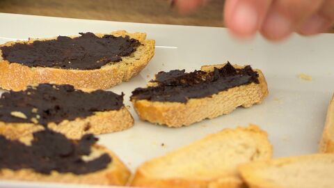 Unta cada rebanada de pan con un ajo negro