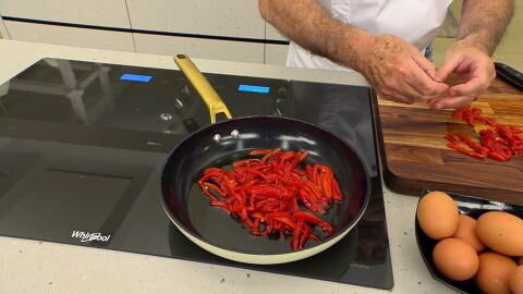 Corta los pimientos en tiras finas, introdúcelos en la sartén