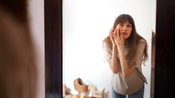 Mujer mir&aacute;ndose el rostro