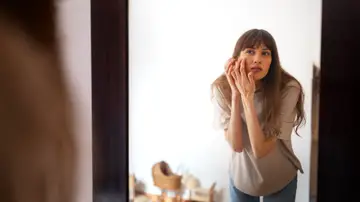 Mujer mirándose el rostro Mujer mirándose el rostro