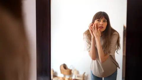 Mujer mirándose el rostro Mujer mirándose el rostro