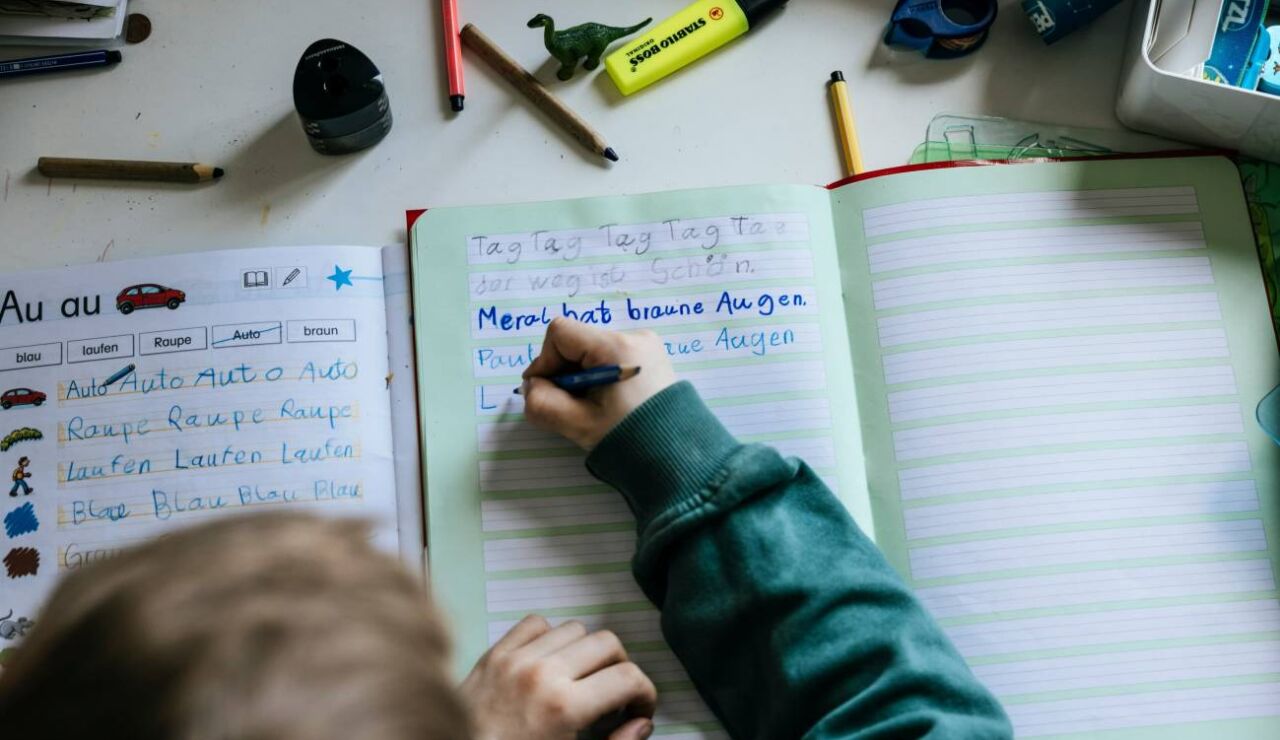Un ni&ntilde;o escribiendo en un cuaderno