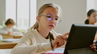 Una alumna usando una tablet en clase