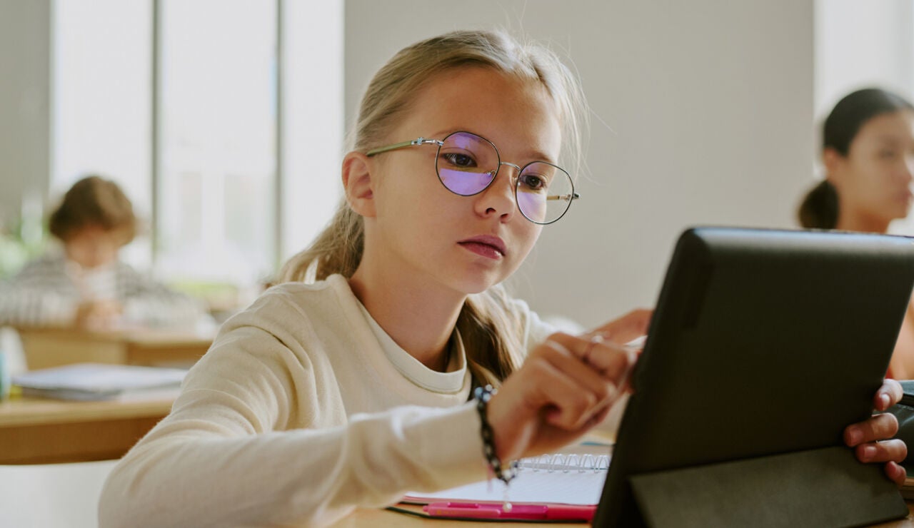 Una alumna usando una tablet en clase