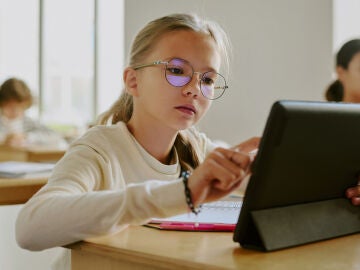 Una alumna usando una tablet en clase Una alumna usando una tablet en clase