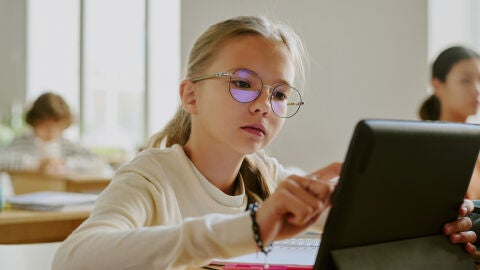 Una alumna usando una tablet en clase