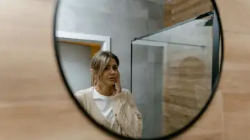 Mujer mirándose en el espejo pensativa Mujer mirándose en el espejo pensativa