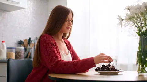 Mujer comiendo cerezas Mujer comiendo cerezas