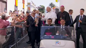 El papa bendice a un niño desde el papa móvil. El papa bendice a un niño desde el papa móvil.