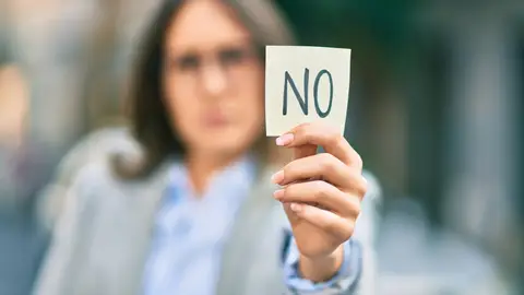 Mujer sujeta un papel con un "no" escrito Mujer sujeta un papel con un "no" escrito