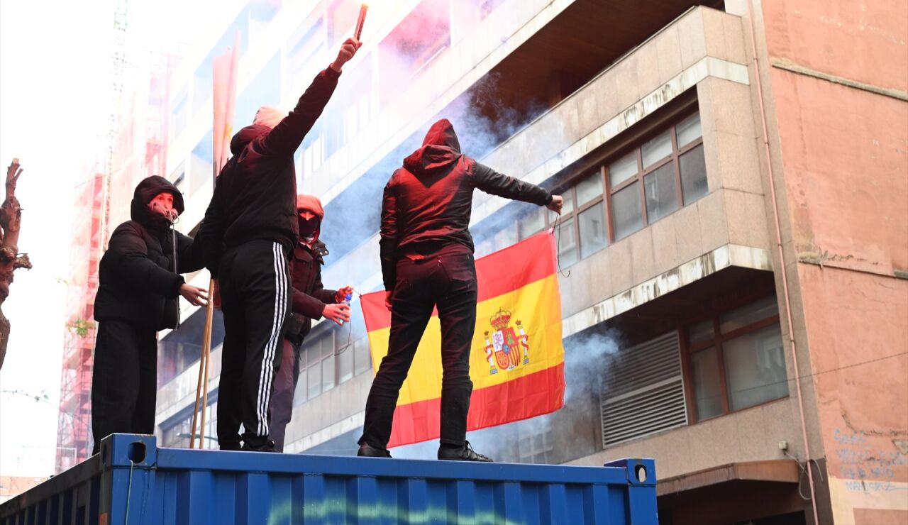 Manifestantes queman una bandera de Espa&ntilde;a.