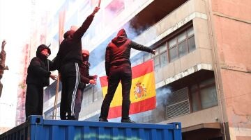Manifestantes queman una bandera de Espa&ntilde;a.