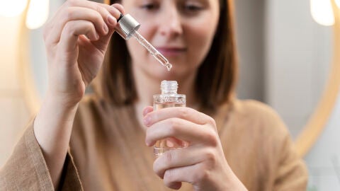 Mujer con un bote de cosmético en las manos