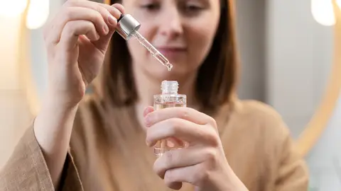 Mujer con un bote de cosmético en las manos Mujer con un bote de cosmético en las manos