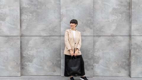 Mujer posa con una americana beige