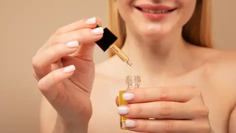 Mujer con un cosmético en la mano Mujer con un cosmético en la mano