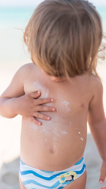 Bebé que se está poniendo crema solar