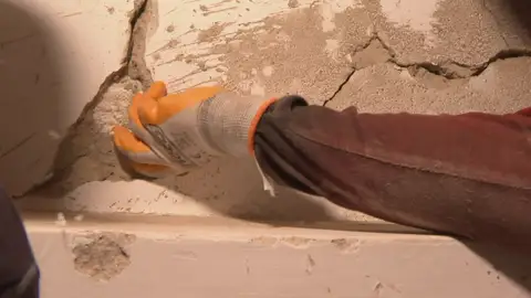 Un operario rompe con facilidad una de las paredes de un edificio dañado tras los terremotos en Venezuela Un operario rompe con facilidad una de las paredes de un edificio dañado tras los terremotos en Venezuela