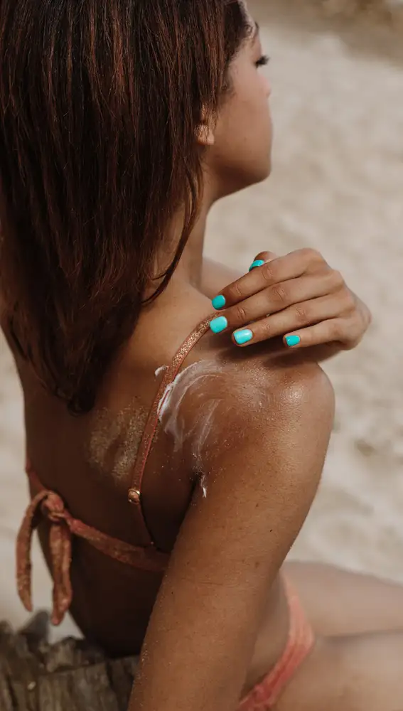 Mujer poniéndose crema de sol Mujer poniéndose crema de sol