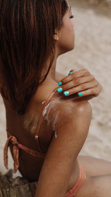Mujer poniéndose crema de sol