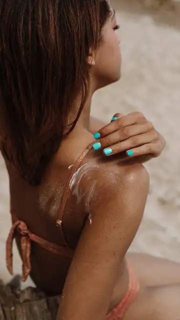 Mujer poniéndose crema de sol Mujer poniéndose crema de sol
