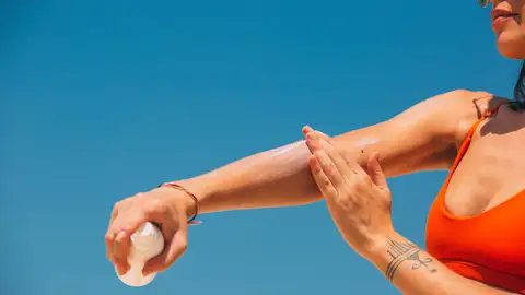 Mujer poniéndose crema de sol Mujer poniéndose crema de sol