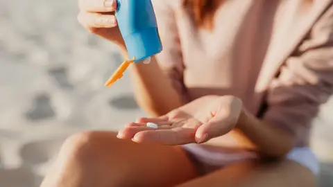Mujer poniéndose crema de sol Mujer poniéndose crema de sol